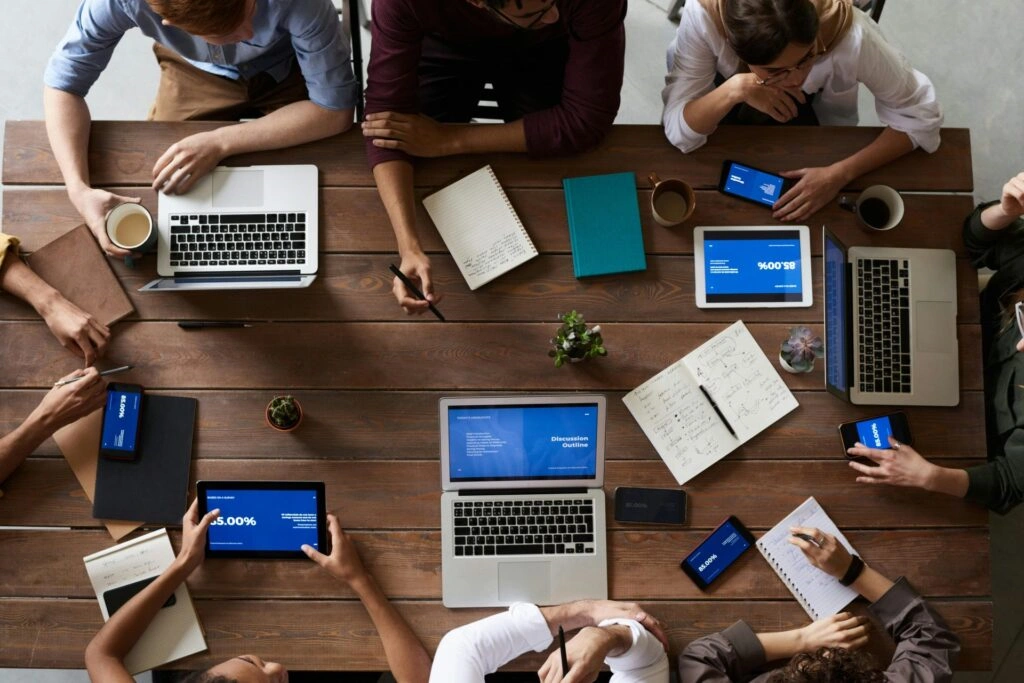 Team collaborating with laptops & smartphones - Business Automation
